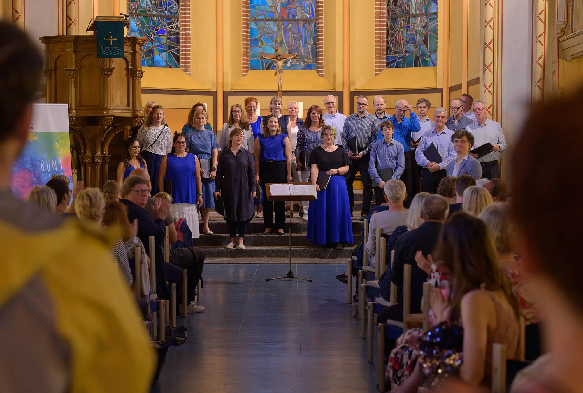 amici musicae berlin beim Konzert in der Magdalenen Kirche bei der Fête de la musique. Am Ende der Kirche steht der Chor in blauer Chorkleidung. Rechts und links ist das Publikum zu sehen.